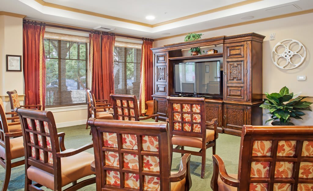 A cozy living room with wooden furniture and a large TV, offering a warm and inviting space.