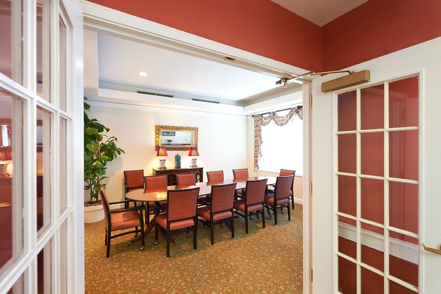 A well-furnished dining or conference room with a long table and chairs arranged neatly.
