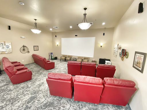 A cozy home theater featuring red seating and a large projector screen, perfect for movie nights.