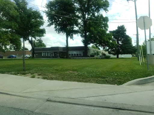 A view of a building surrounded by trees and open grass.