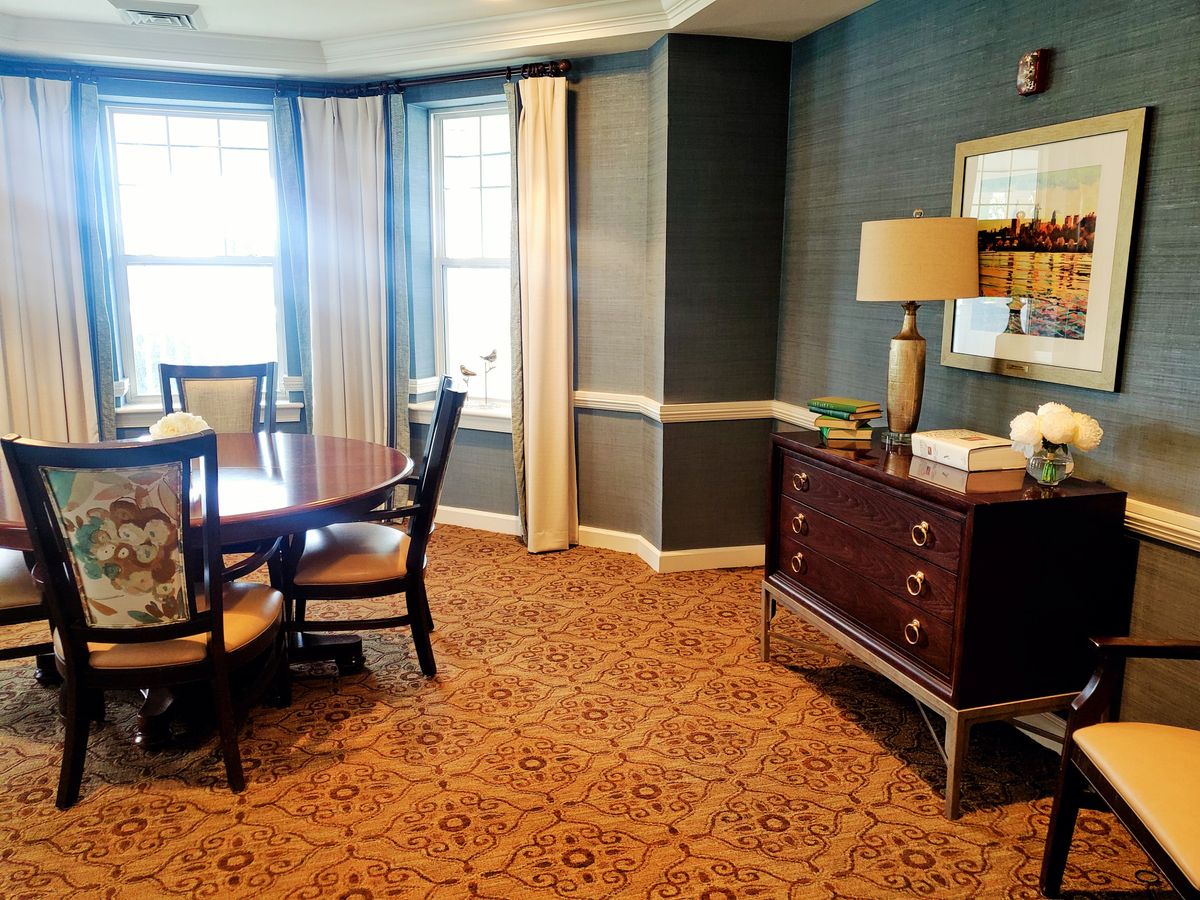 A cozy dining room with elegant furniture and large windows.