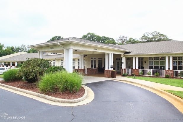 A building with a covered entrance and landscaped driveway.