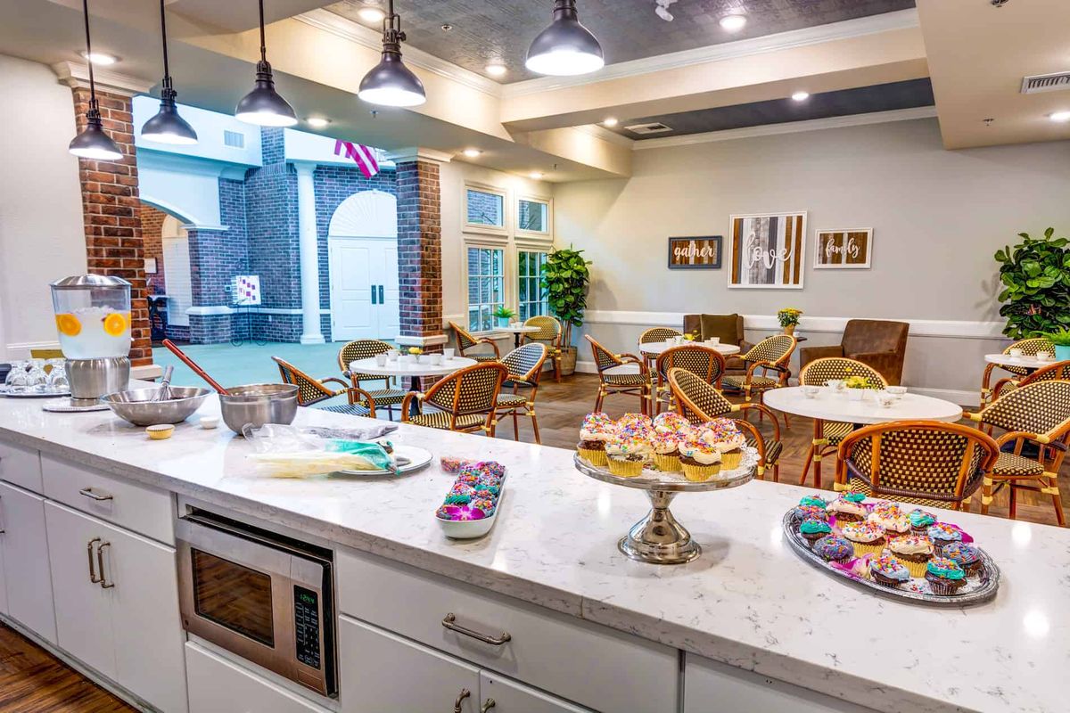 A cozy cafe interior with pastries displayed on a countertop and comfortable seating areas.