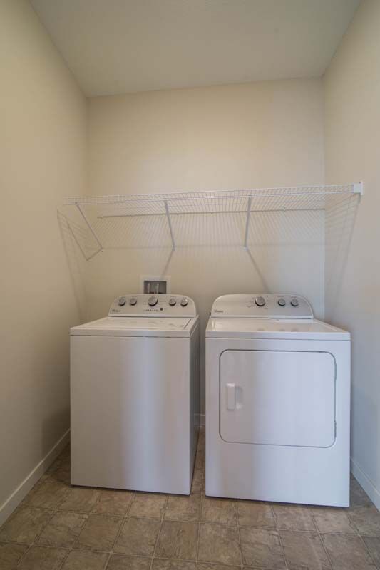 A tidy laundry room with a washer and dryer side by side.