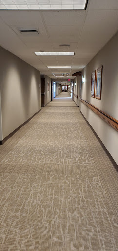 A well-lit corridor with patterned carpet and soft lighting, showcasing a modern interior design.