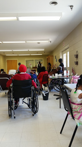 A community gathering in a care facility where elderly individuals engage in social activities.