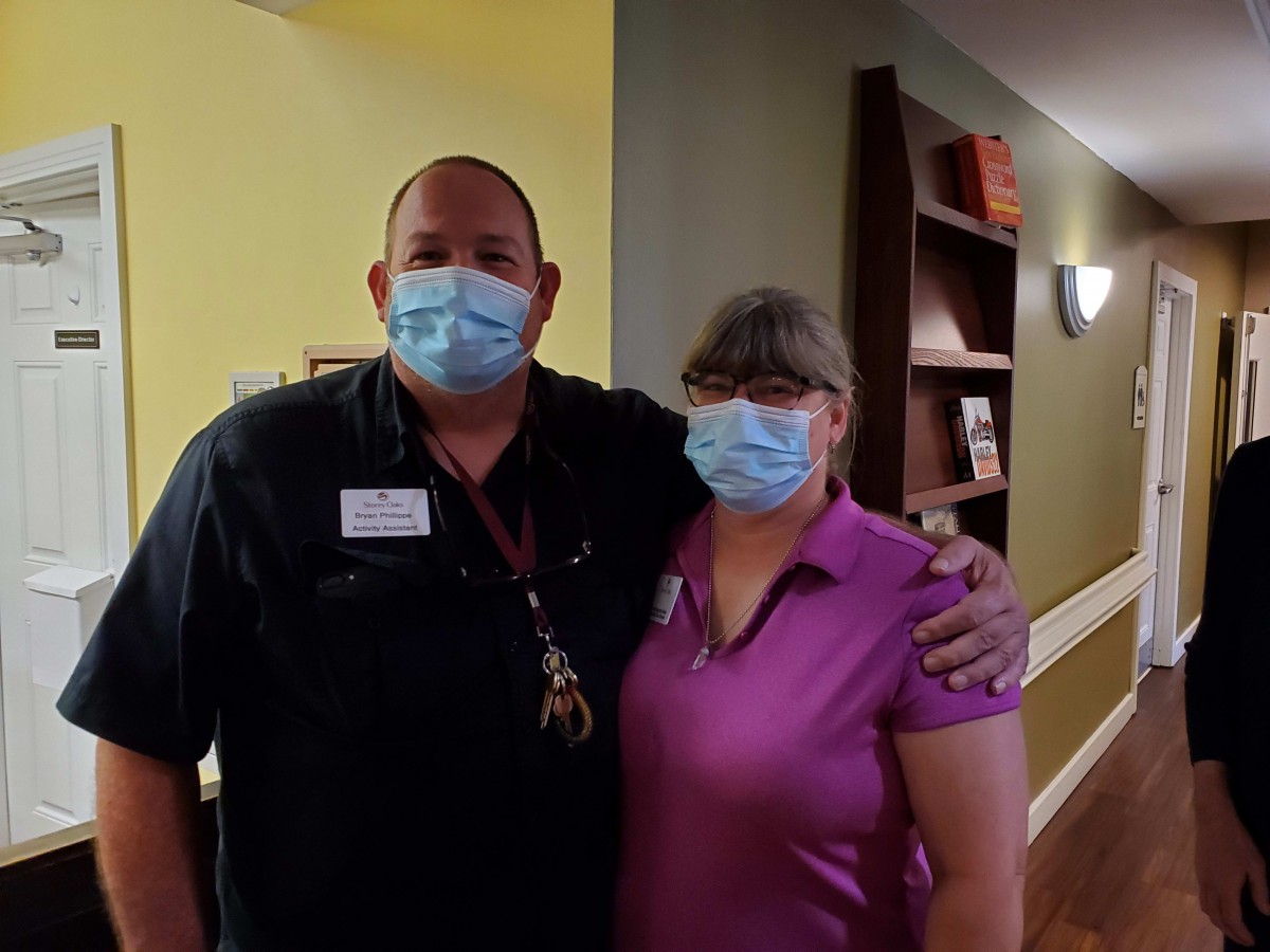 Two people wearing masks in a healthcare setting.