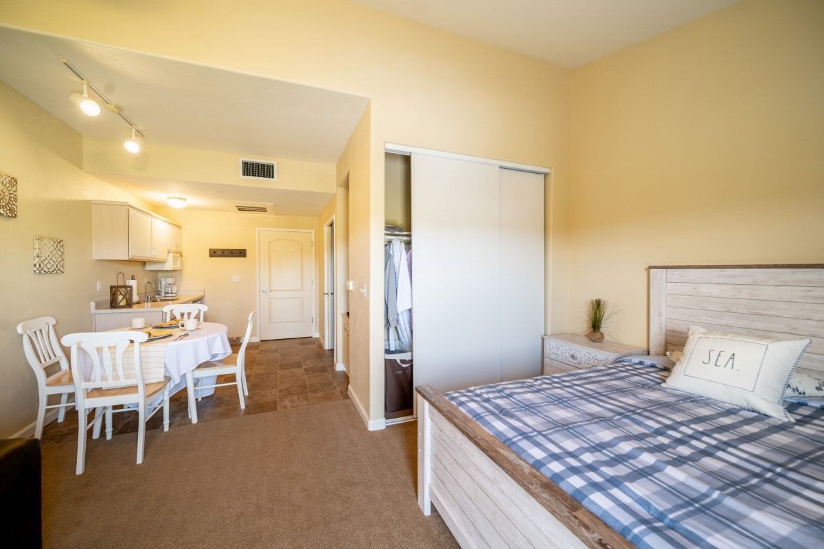 A cozy living space featuring a bedroom with a bed and a dining area, showcasing elegant interior design.