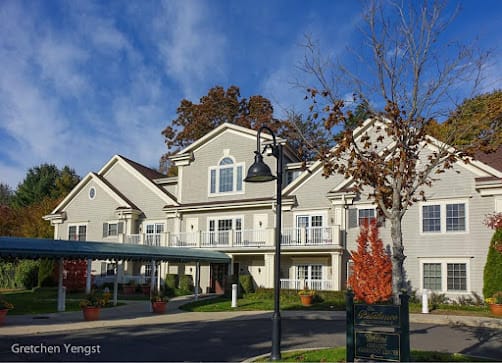 A residential building with autumn trees and a clear blue sky.