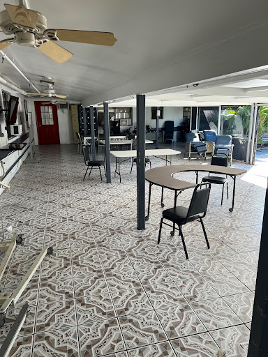 A spacious interior setting featuring tables and chairs arranged neatly on a patterned floor.