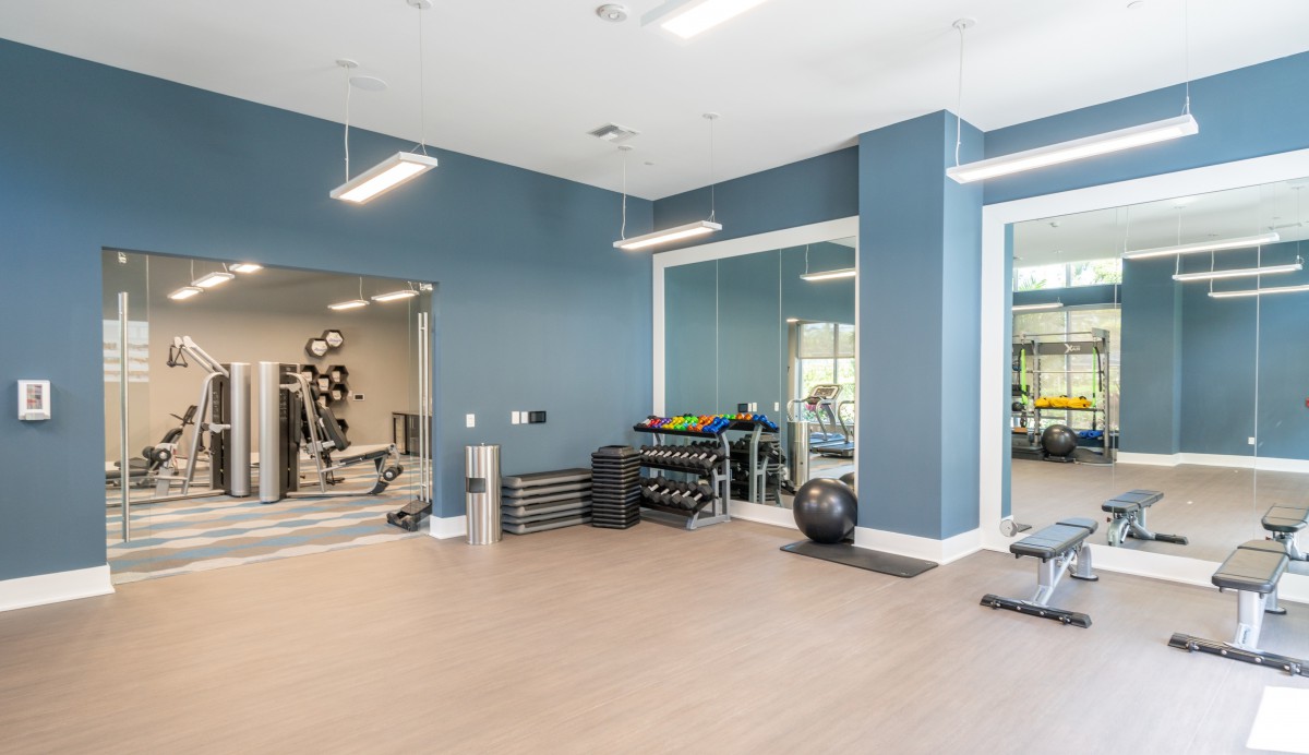 A modern gym with exercise equipment and mirrored walls.
