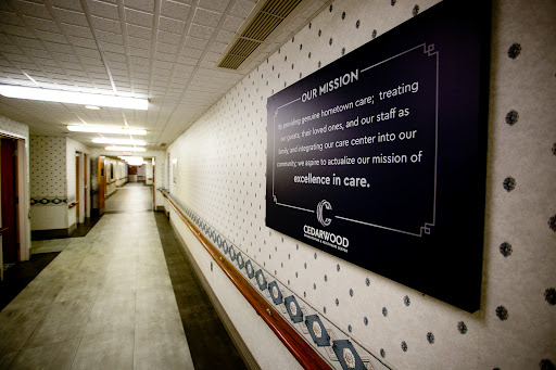 A corridor in a hospital featuring a mission statement on the wall, emphasizing the institution's commitment to care and excellence.