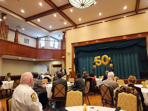 A gathering celebrating a significant 50th anniversary, with decorations and an engaged audience.