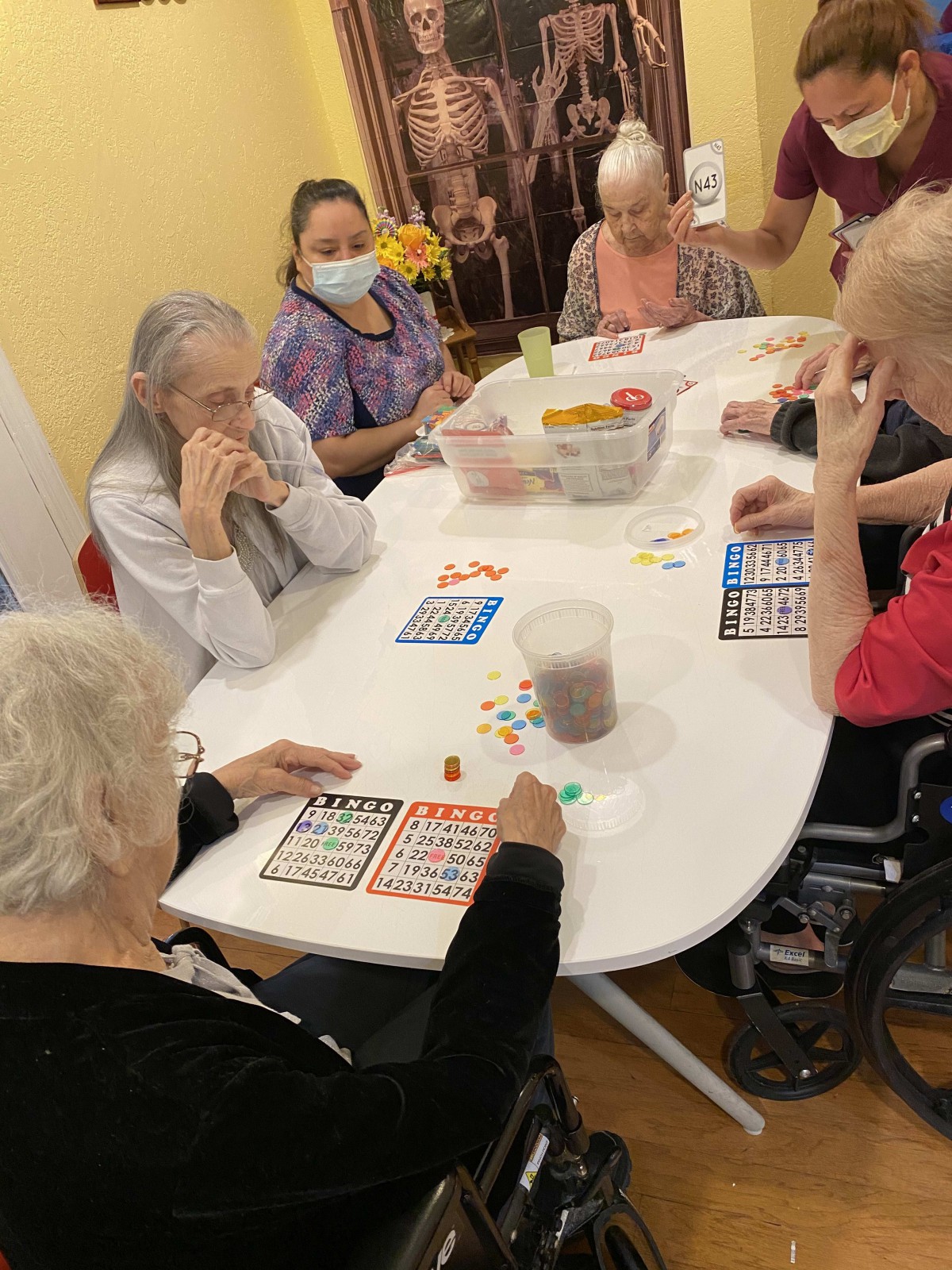 A group of elderly individuals playing bingo together at a table.