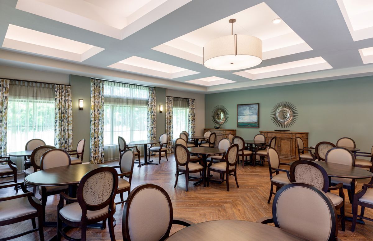 A well-lit dining room with elegant furniture and large windows.