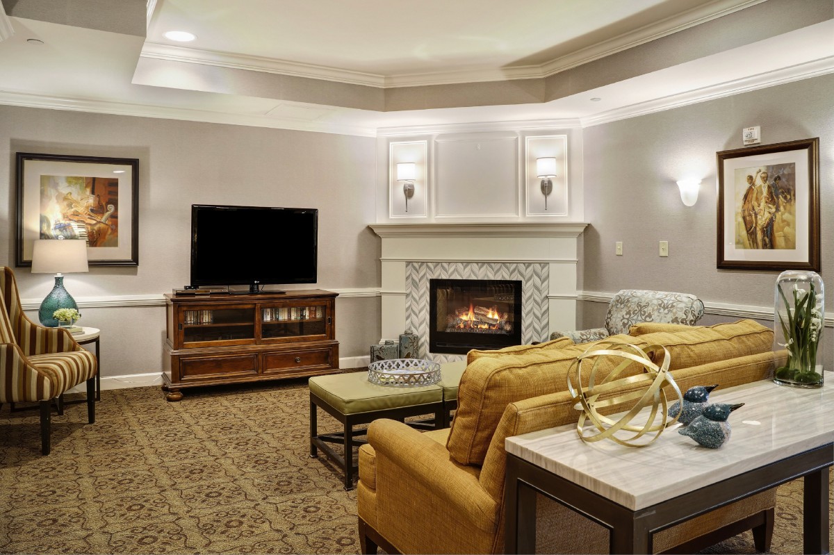 A cozy living room with a fireplace and television, featuring comfortable sofas and stylish decor.