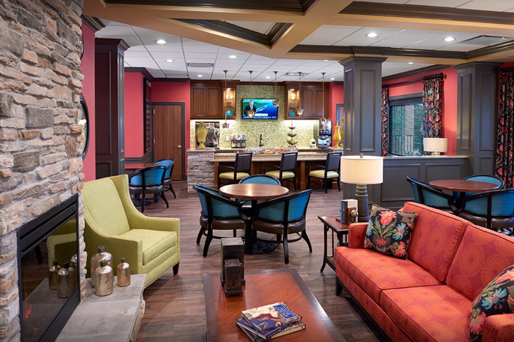 A modern lounge area with colorful seating and a bar in the background, creating a cozy atmosphere.