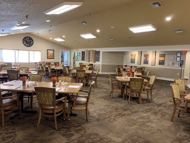 A spacious dining area with neatly arranged tables and chairs, featuring warm interior decor.
