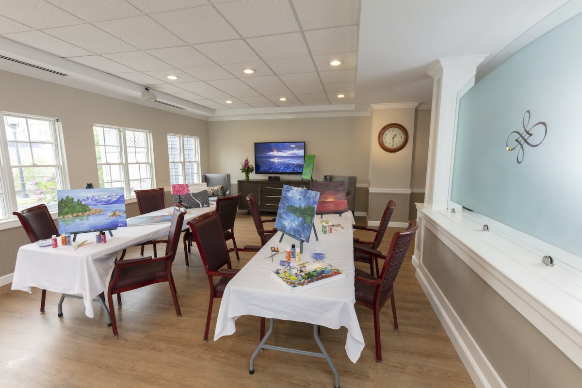 A community room set up for a painting class with tables and art supplies.