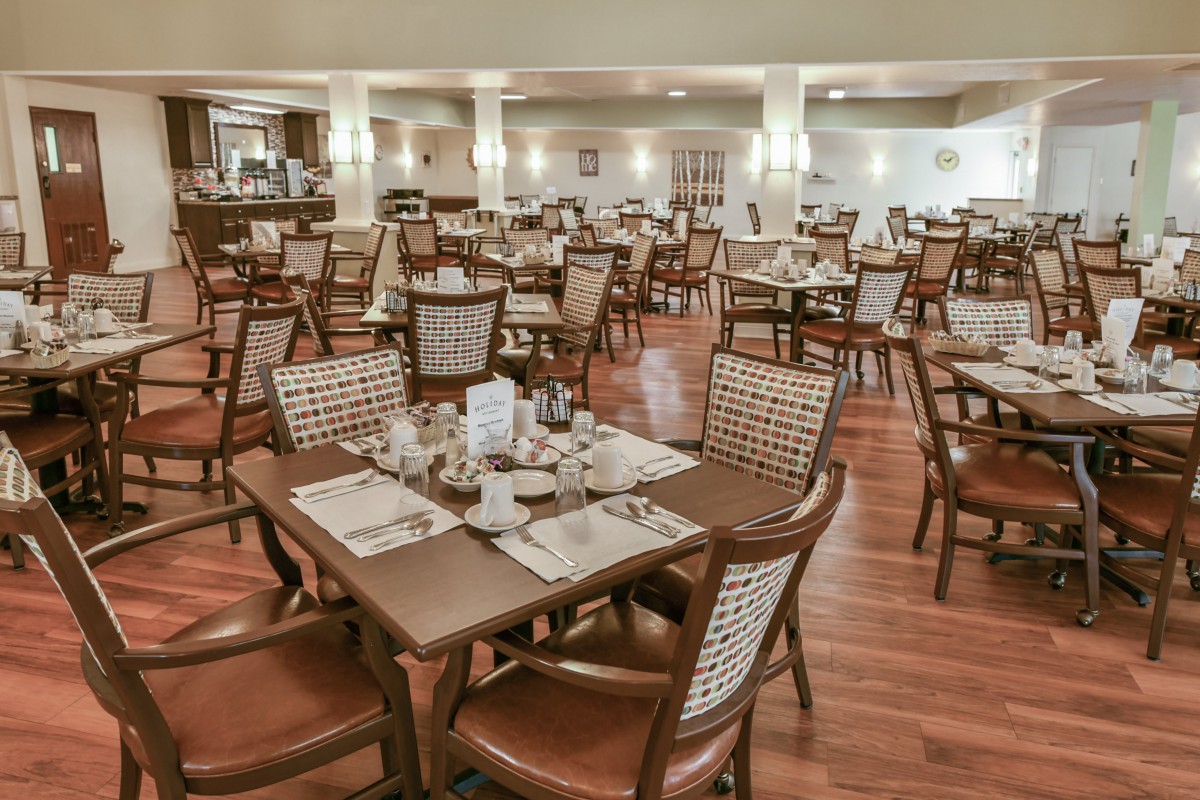 An empty dining area with neatly arranged tables and chairs in a restaurant.