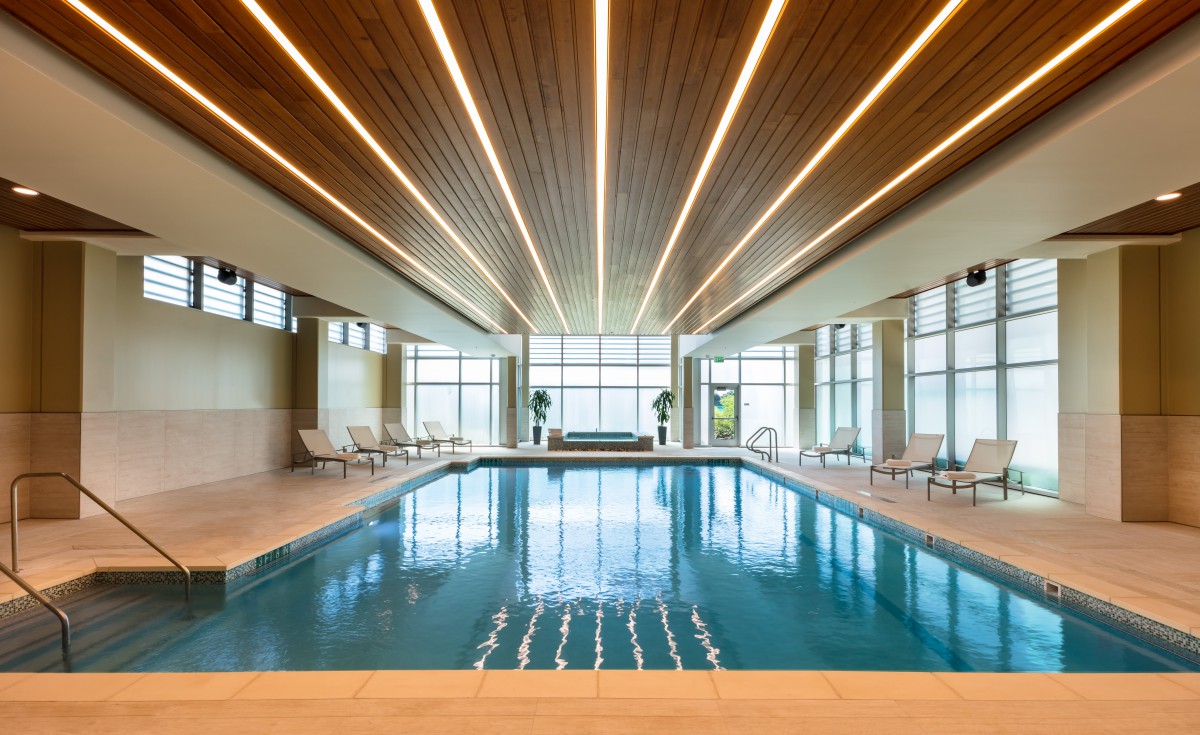 A luxurious indoor swimming pool with modern lighting and sleek architectural design.