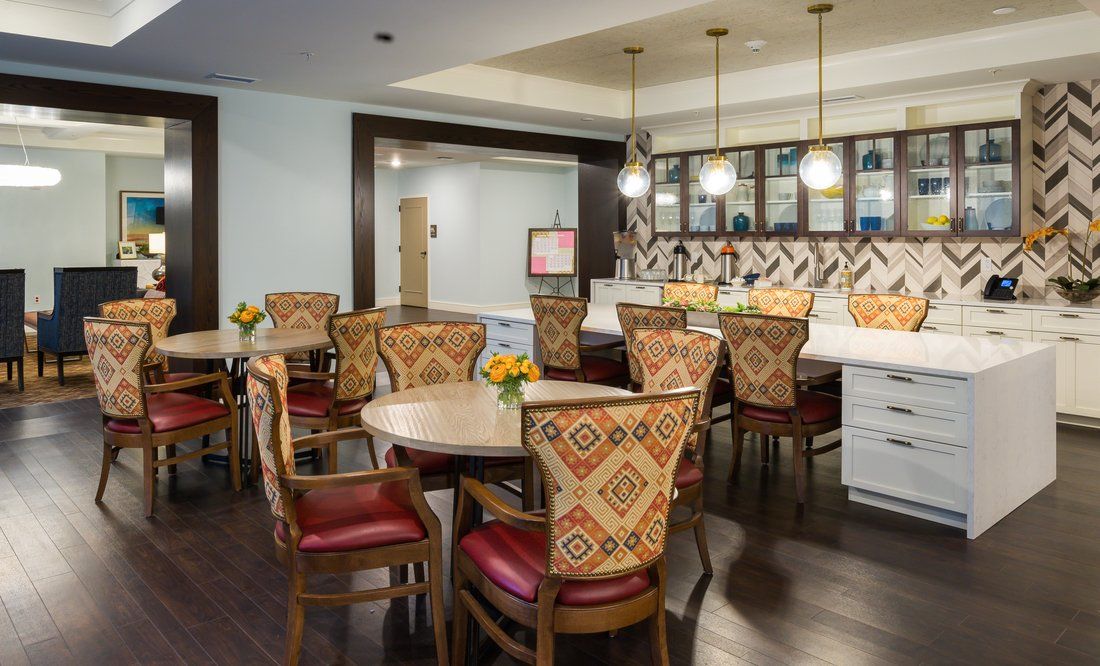 A cozy dining area with patterned chairs and a bar counter, featuring modern lighting and decor.
