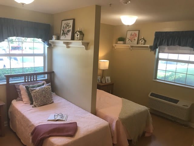 A cozy shared bedroom with twin beds, decorated with soft colors and personal touches.