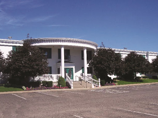 A modern building featuring classical architectural elements, surrounded by a clear blue sky.