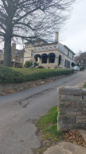 A picturesque view of a uniquely designed house nestled along a winding road.