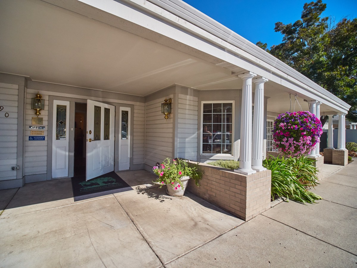 A welcoming entrance with white columns and colorful flowers.