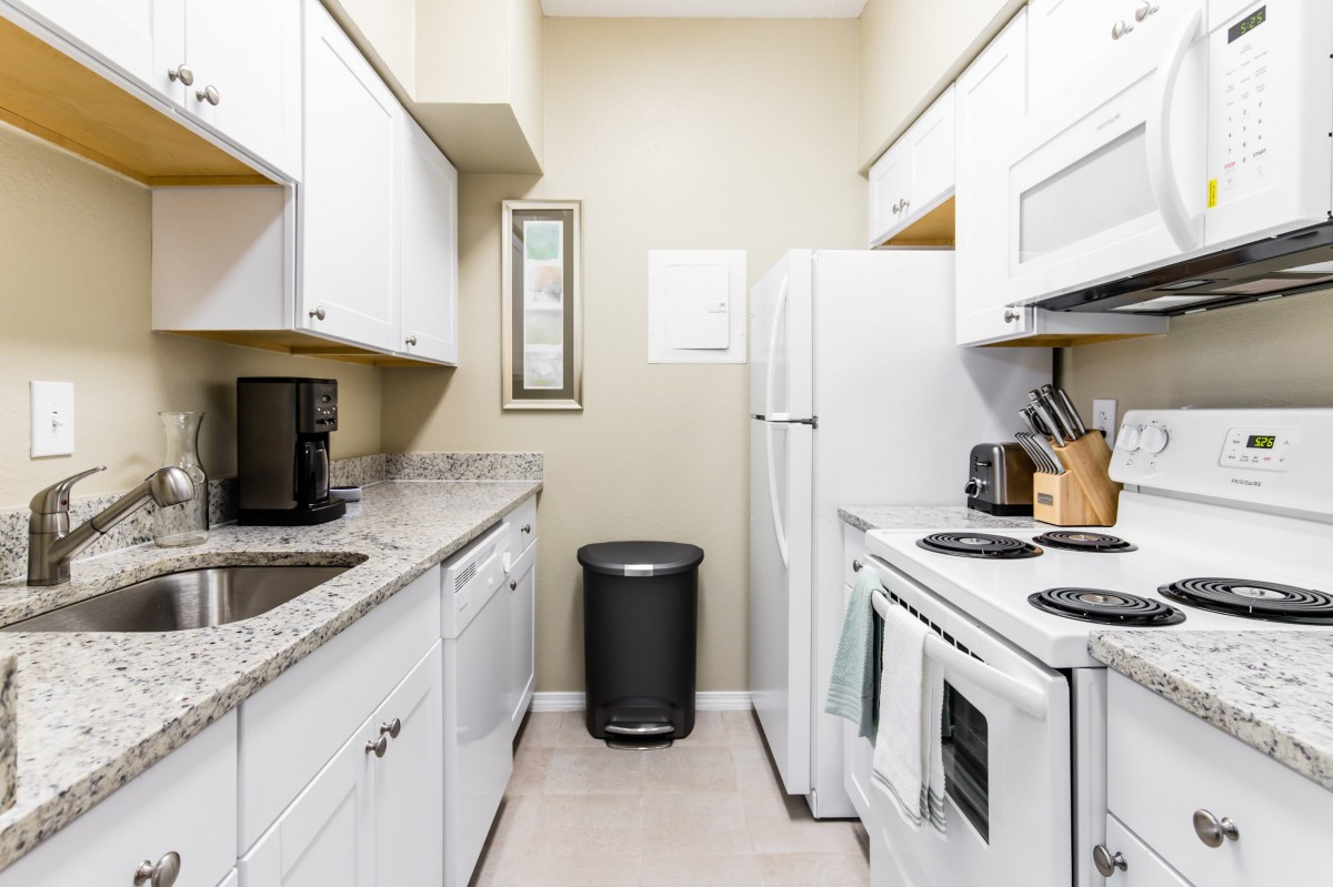 A clean and organized kitchen with white cabinets and modern appliances.