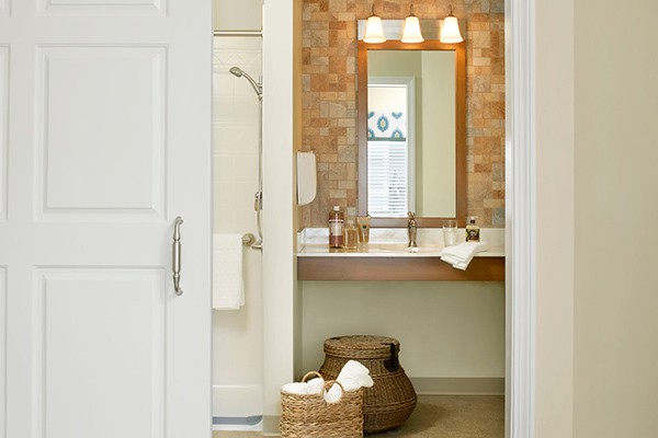 A cozy bathroom with a modern sink, large mirror, and decorative baskets.