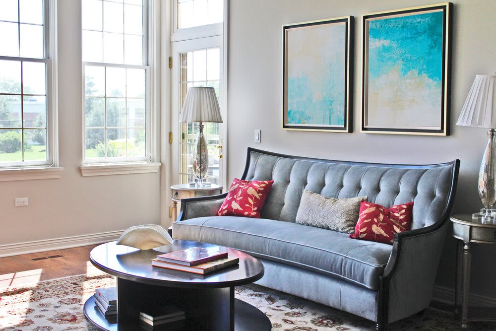 A cozy living room with a stylish sofa, colorful pillows, and abstract artwork.