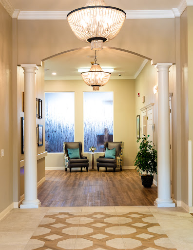 A welcoming entrance hall featuring elegant columns, cozy seating, and stylish lighting.