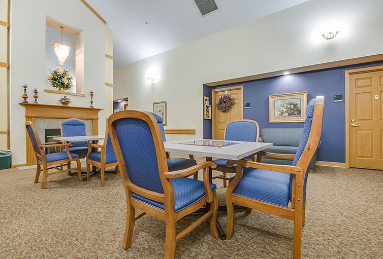A cozy dining area with blue upholstered chairs and a wooden table.