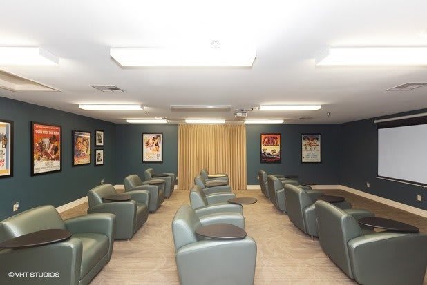 A spacious waiting room with comfortable seating and wall posters.