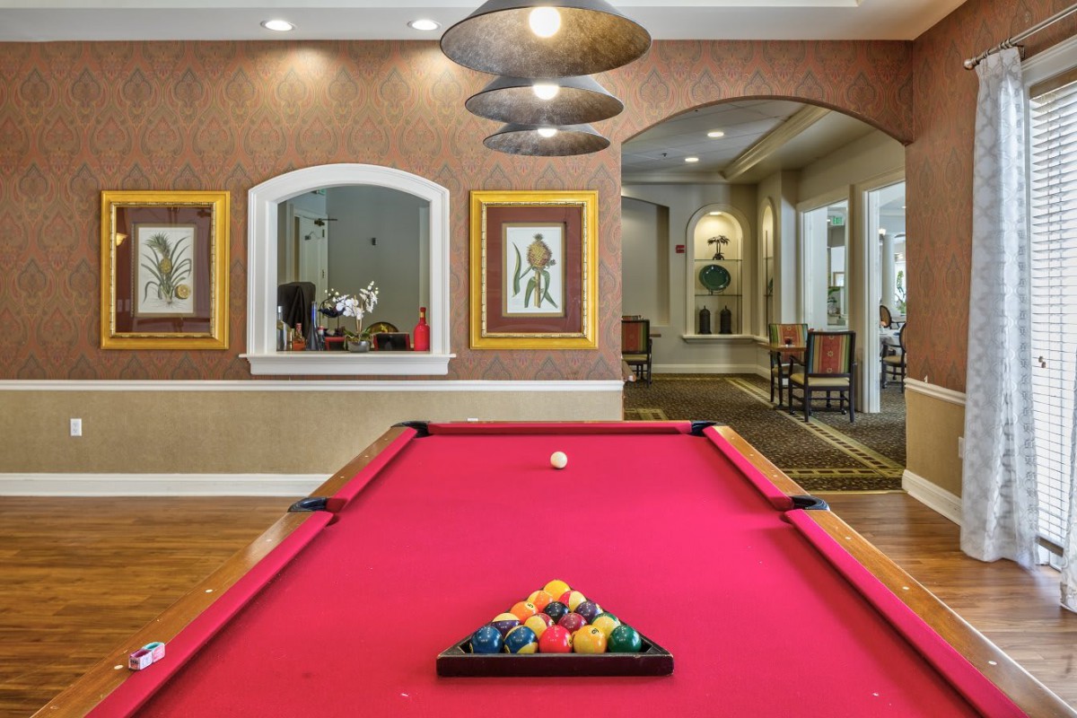 A stylish recreation room with a red pool table and modern decor.