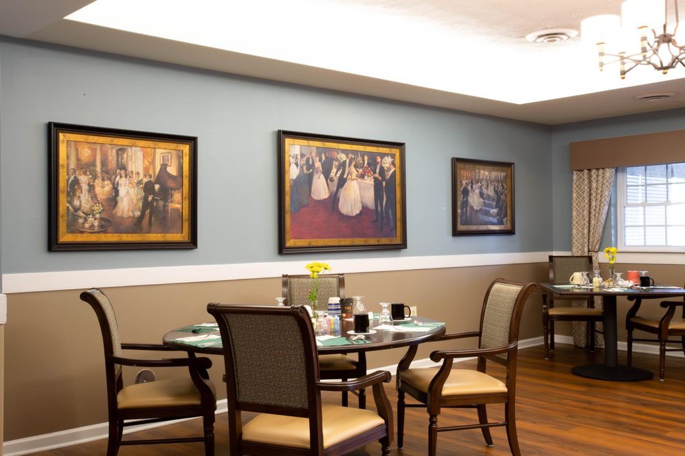 A cozy dining area with elegant paintings adorning the walls.