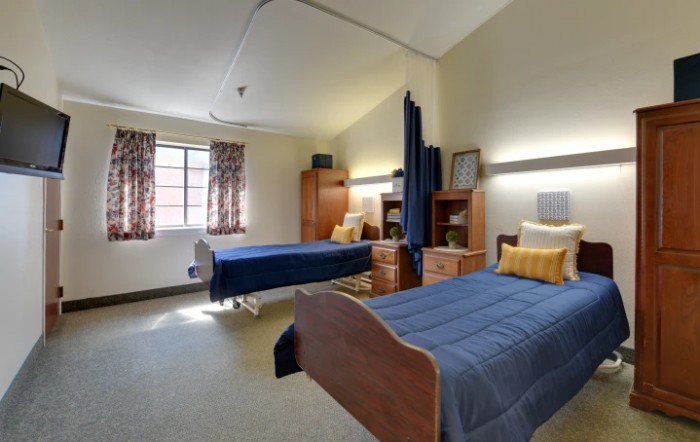 A cozy, well-furnished bedroom with two beds and ample natural light.