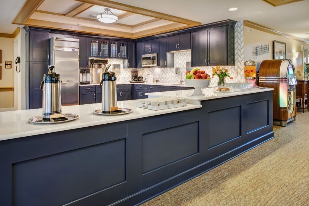 A modern kitchen with dark cabinetry and a stylish coffee station.