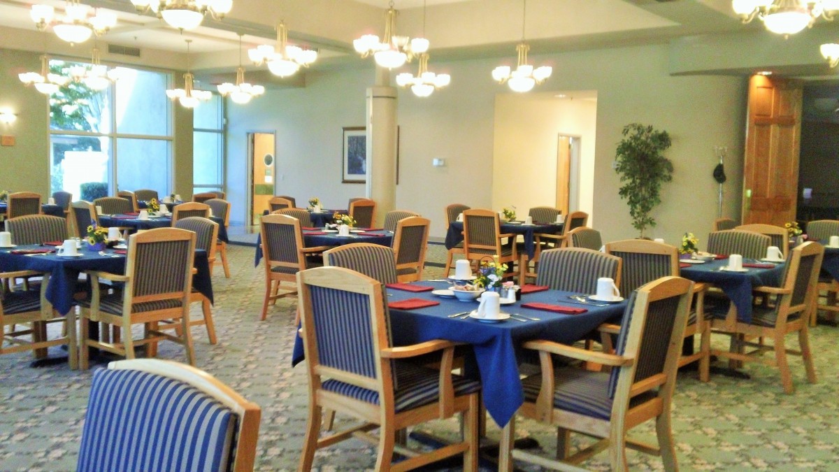 A well-lit dining area with neatly arranged tables and chairs.