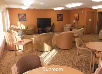 A cozy sunroom with comfortable seating and warm lighting.