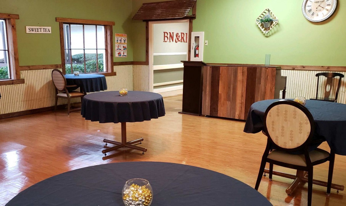 Interior view of an empty restaurant with round tables and a cozy atmosphere.