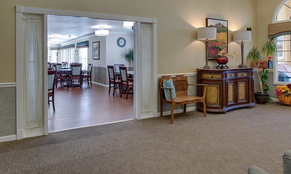 A cozy living space connected to a dining area, featuring elegant furniture and tasteful dcor.