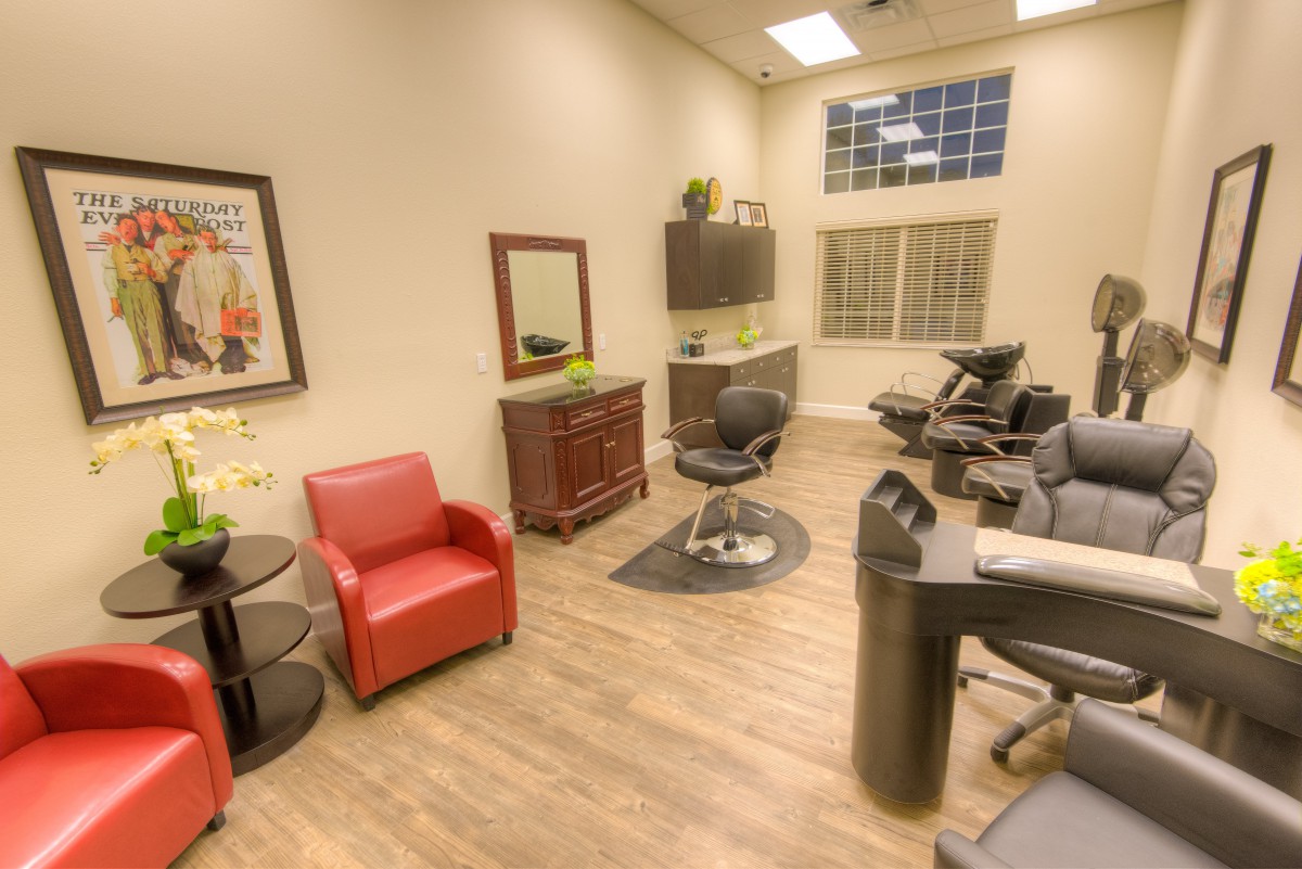 A cozy salon interior with comfortable chairs and a mirror.