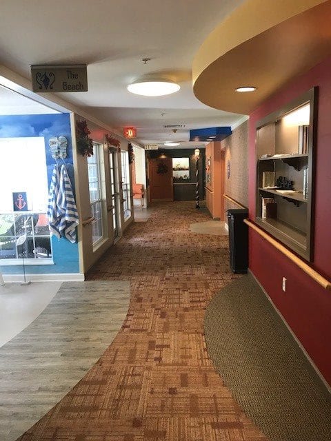 A modern commercial hallway with colorful walls and patterned carpeting.