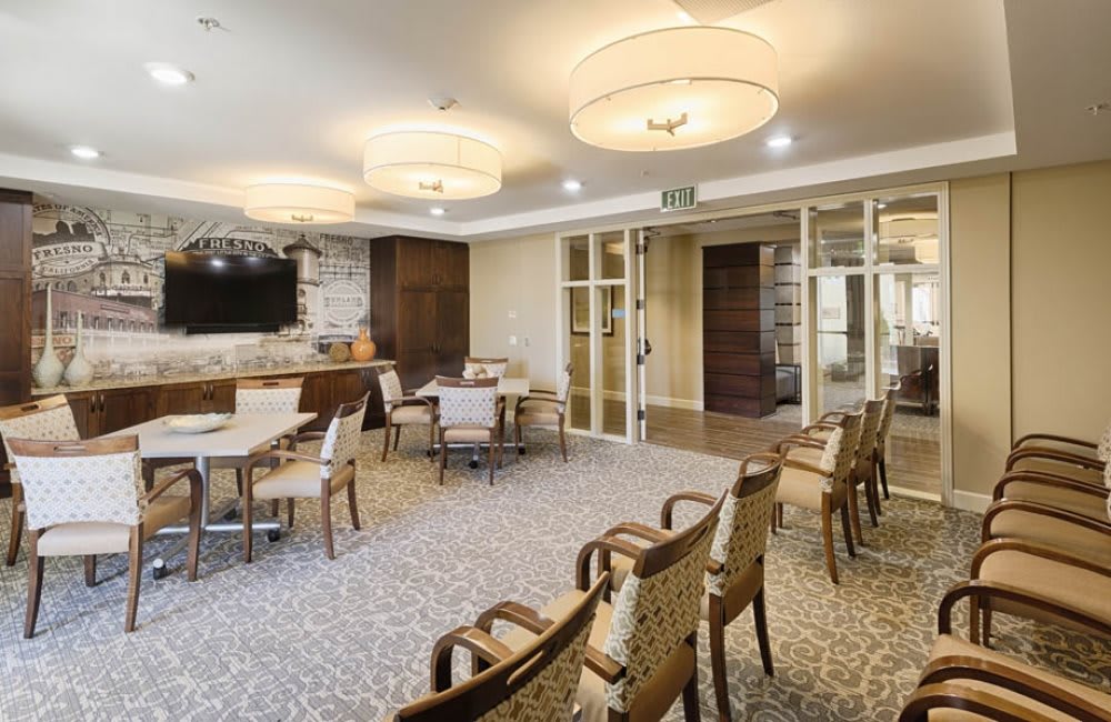 A modern meeting room with arranged chairs and tables, featuring stylish lighting fixtures.