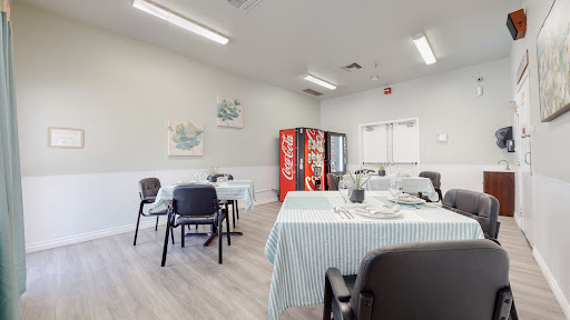 A cozy dining area featuring striped tablecloths and a Coca-Cola vending machine.
