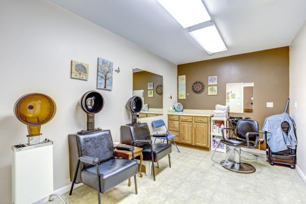 A well-organized hair salon with seating, dryers, and stylish decor.