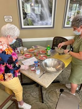 Two people preparing ingredients for baking at a table.